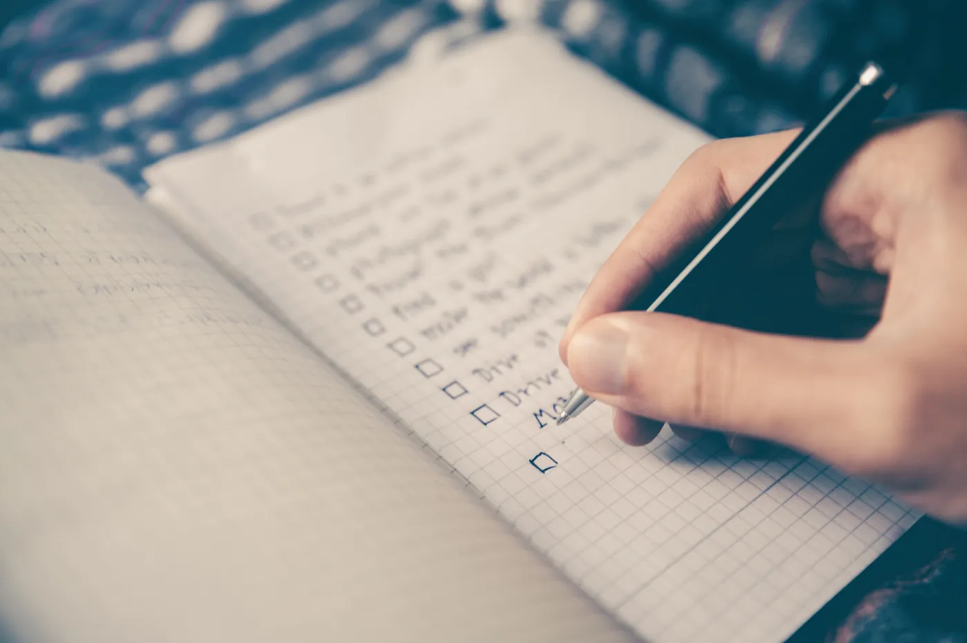 “A person making a checklist in a notebook” by Glenn Carstens-Peters on Unsplash